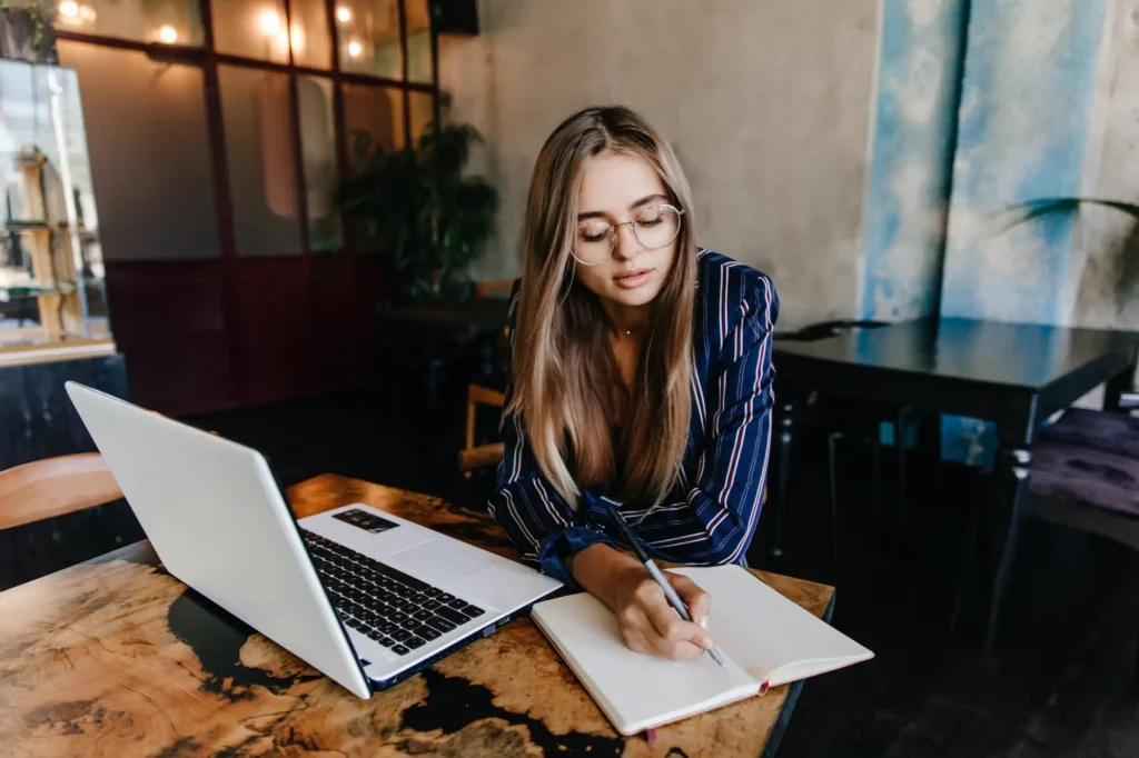 a woman writing in a notebook - environmental science homework help